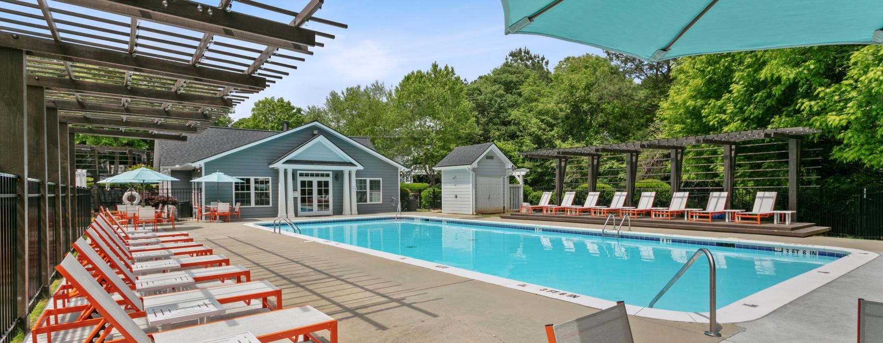 a swimming pool with a deck and chairs