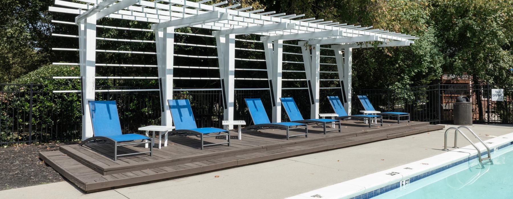 a swimming pool with chairs and a covered area